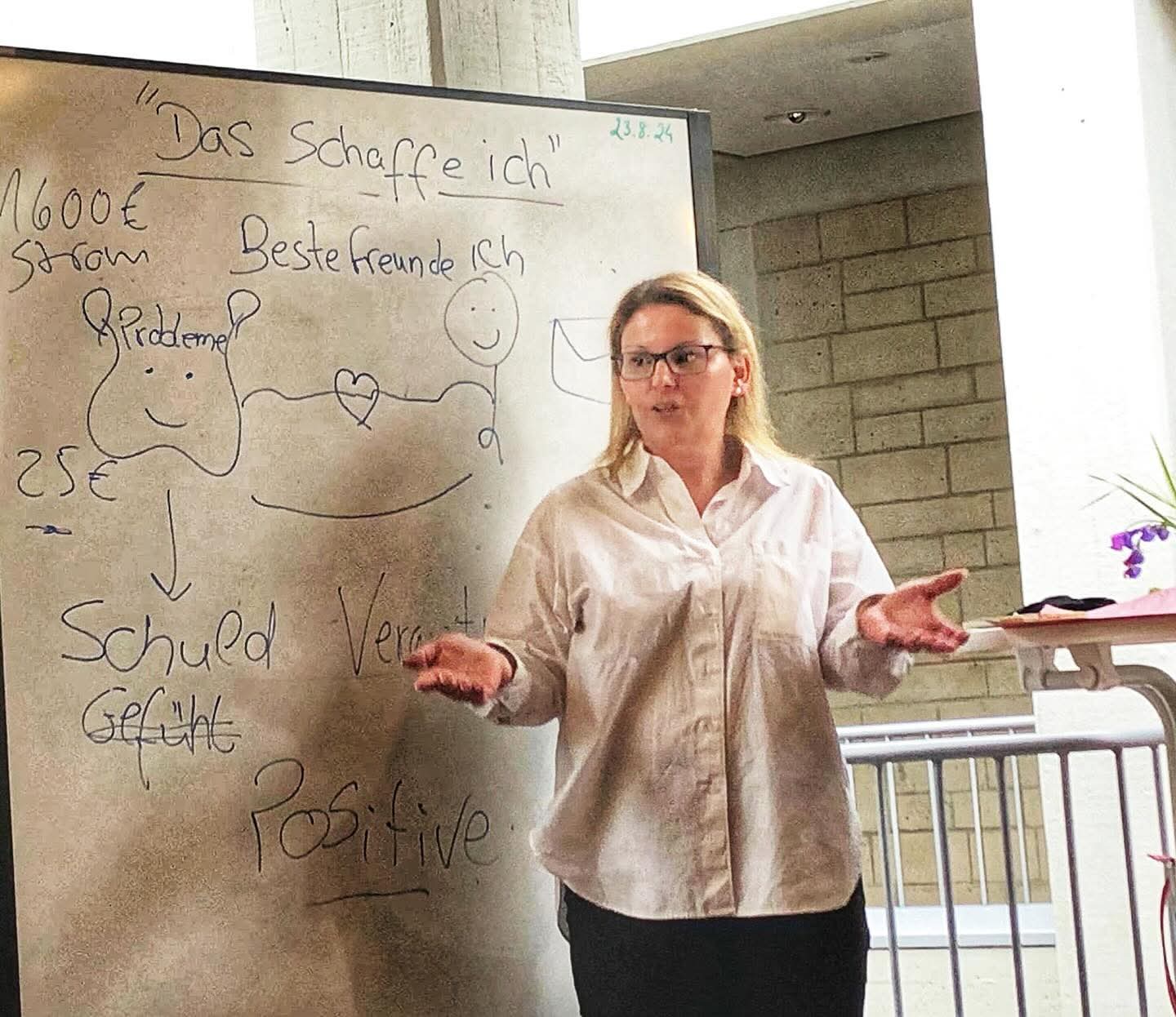 Teresa Correia am Whiteboard: gemeinsames Erarbeiten von Alltagsthemen wie Finanzen, Schuldgefühle und positive Perspektiven.
